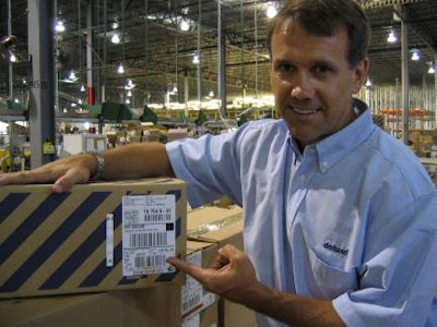 Deluxe's director of engineering Jeff Nelson points to a small naked tag that RFID-enables a case of DVDs. In another app