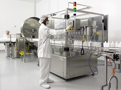 Standing in front of the eight-head piston filler, a PharmaFab employee monitors production on the company's new liquid pharmac