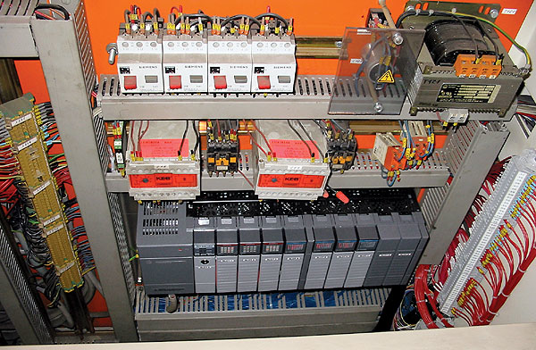 Above, a new SLC now sits at the bottom of the controls cabinet for Truitt Bros.' tray-packer/shrink-wrapper system, replacing a