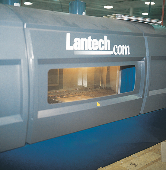 Two side windows in this heat tunnel allow Platinum Packaging personnel to view film shrinking around a thin pack of gift boxes