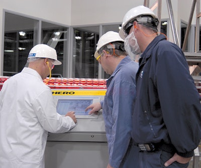 Ocean Spray personnel, including plant manager Paul Altimier (in white), gather around the system's touchscreen panel to check t