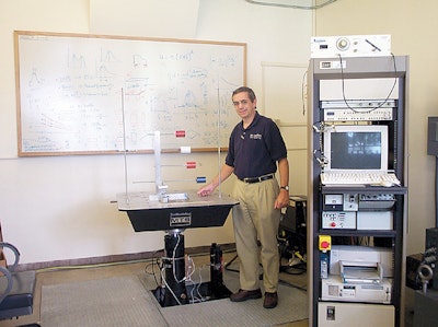 Inside the packaging lab at SJSU, packaging program director Herbert Schueneman poses next to a vibration tester.