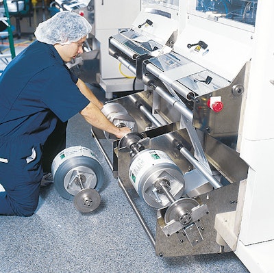Line technician Omar Micheo loads a fresh roll of foil-based film to one of the six f/f/s machines that wrap Nephron's vials.