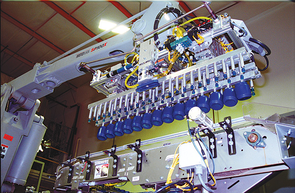 Depending on the jar diameter, the robot selects one of six end-of-arm tool heads to pick up as many as 16 jars at once as they