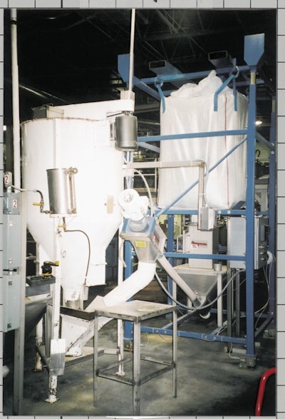 Snyder of Berlin's bulk bag unloader discharges 2,000 lb of cornmeal into a hopper before a 4 '-diameter flexible screw conveyor