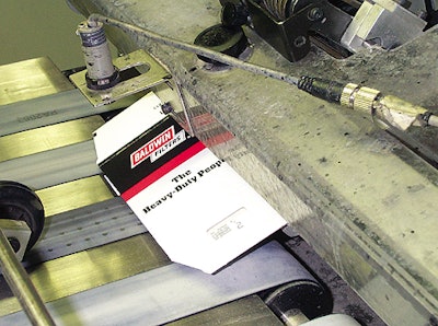 Individual carton blanks are drawn out of a magazine by a belt friction feeder and then held flat by a vacuum belt conveyor.