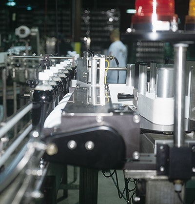 Bottles index single file from front to back through a timing screw (left) before a label is wiped on.