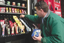 A vending machine operator stocks dog candy and breath mints in a machine at a Maine highway rest stop.
