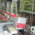 The cases are tilted for two-up loading (above) to keep the cartons forward so that a vertical divider can be inserted by the ro