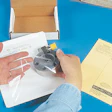 After folding two side flaps, an operator inserts the sensor product (above) between the package's corrugated and film material.