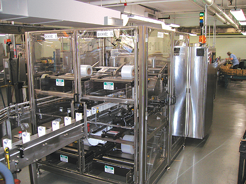 Cartoned bottles march in single file into the entrance of the shrink wrapper at rates to 100/min (left) and emerge neatly bundl