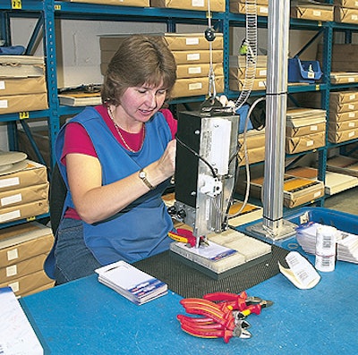 A Draper Tools operator presses a trigger on the machine that releases a fastener that secures the tool to the display card.