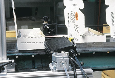 In GBF's semi-automatic packaging line, boxes are set up automatically (right) then loaded with literature before the components