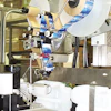 This labeler's sliding head makes it possible to apply labels on a bottle's top or side panel.