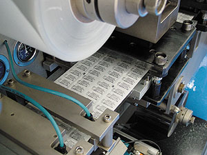 At this blister sealer, printed lid stock with a truncated bar code is applied and heat sealed to a blister containing medicatio