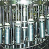 Backside view shows the cam-operated platforms under each bottle that raise and lower during the filling cycle to minimize splas