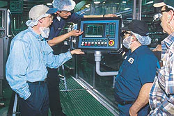 Poland Spring personnel and Christian Schlichtenbrede (in back) of Kisters Kayat observe a control panel for a multipacker used