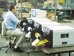 Lou Raucci, manager of packaging at Amertac, loads a print order behind the three new label printers.