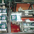 The system shown here includes a robotic positioner that picks a bundle of 12-count corrugated shippers, orients the bundle, cut