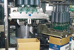 Bottles are removed from reshippers by a continuous-motion rotary-style uncaser (left).