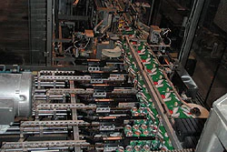 Southeast Canners uses the machine (above) to open a paperboard carrier, load 12-oz cans into it, then seal it shut.