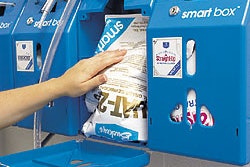 A maintenance worker places the new Smart Sac Stand-up Pouch inside the Smart Box containing unit for proportioning and dispensi