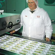 Craig Reichel admires freshly sliced apples that have just been loaded into trays thermoformed on used, rebuilt equipment.