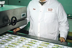 Craig Reichel admires freshly sliced apples that have just been loaded into trays thermoformed on used, rebuilt equipment.