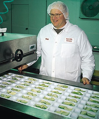 Craig Reichel admires freshly sliced apples that have just been loaded into trays thermoformed on used, rebuilt equipment.