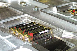 Integrated section comprises 8-up clamshell denesting onto a custom conveyor that moves left to right (above). Midway of the mac