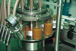 The rotary filler (top) is driven by a motor capable of handling Robson's viscous spun honey. A slight indentation in each bottl