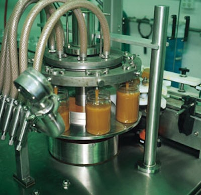 The rotary filler (top) is driven by a motor capable of handling Robson's viscous spun honey. A slight indentation in each bottl
