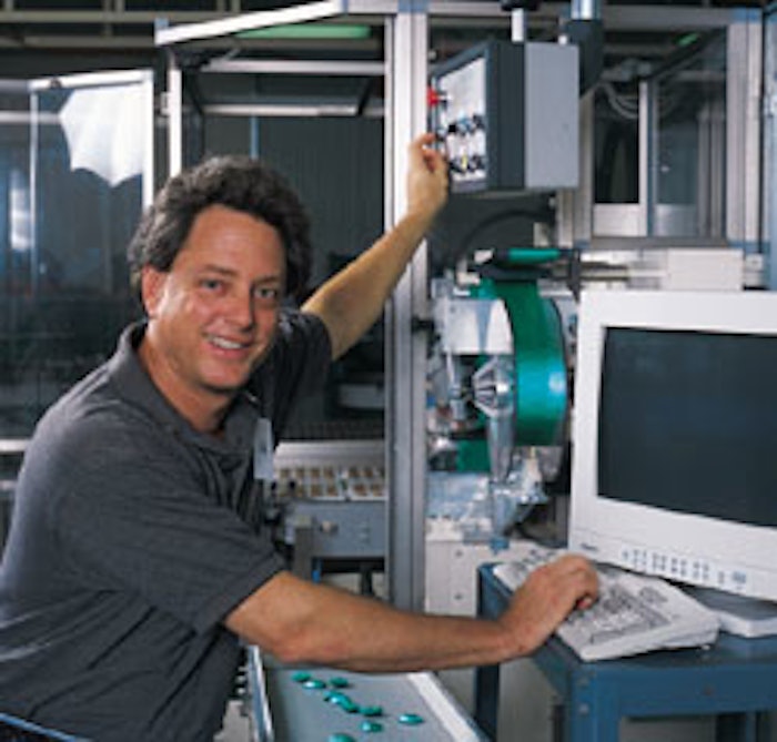 Hank Whetstone pauses at the PC keyboard through which he controls his high-speed candy-wrapping machine.