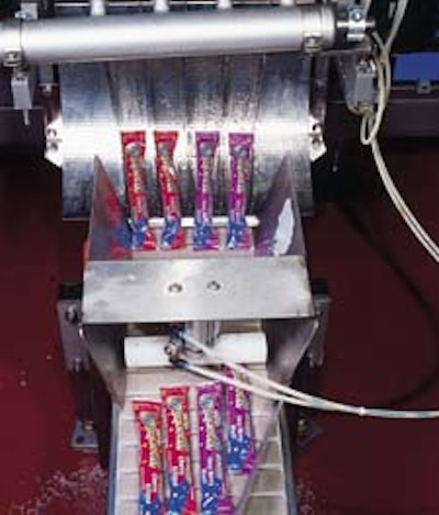 The vf/f/s machine discharges four filled and sealed packs at a time (above). The equipment heat-seals a strip of unprinted film