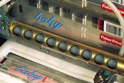 The labeler uses two parallel conveyors (below). In this photo, an open, toothbrush-filled case enters the machine from the conv