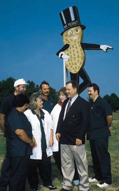 Consultant Terry Barclay (second from right) is shown here with a group of POP trainees before the larger-than-life statue of Mr