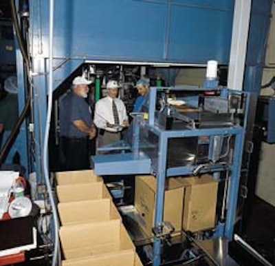 With OR-OSHA and Boyd personnel looking on, erected cases march toward the compact case packer (above). Meanwhile, bags convey f