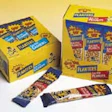 Planters' 'tubed' peanuts are sold at retail in colorful display cartons (above). Photo below left shows the carton infeed stati