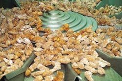 Frozen chicken wings are fanned out to individual weigh buckets by a dispersal cone (above). Bagged chicken drops out of the vf/