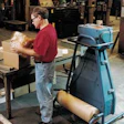 A customer service employee at Mathews uses the PadPak Jr. to prepare spare parts for shipment.