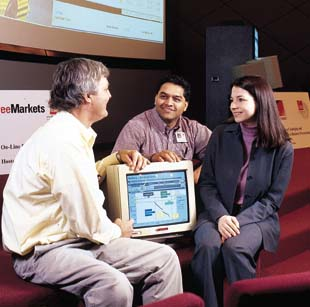 Watching the bid unfold: John Gellatly (left) and Satish Bhagwat of Owens Corning join Kara Csensich of FreeMarkets on bid day.