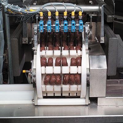 Sara Lee's mini-donut packing system uses an unusual continuous-motion rotary drum loader (seen at left and up close at far left