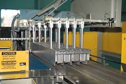 Freshly blown bottles are collated by this row-former and then swept to the left onto a matte-top conveyor. Bottles are held on