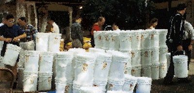 Survivalists unload a shipment of 6-gal buckets containing dehydrated food packaged with oxygen absorbers.