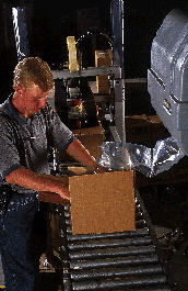 Jason Drum, Heartland America shipping manager, tears off the appropriate number of cushions and inserts them into the boxes to