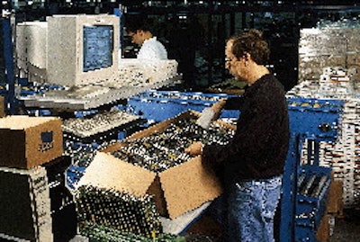 A 3Com employee scans a serial number on an adapter card. That information is entered into the computer at this workstation