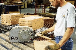 A Steelcase operator pulls a length of reinforced gummed tape from a dispenser for application to a box at the office furniture
