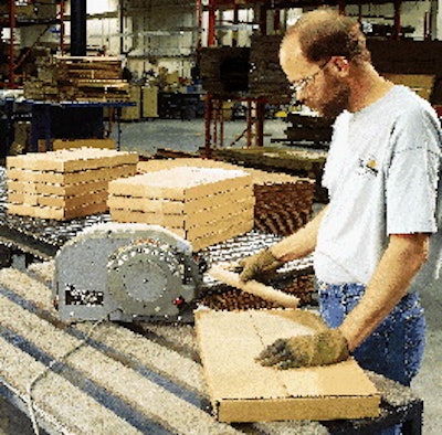 A Steelcase operator pulls a length of reinforced gummed tape from a dispenser for application to a box at the office furniture