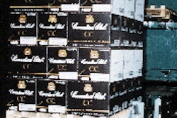 A pallet load of Canadian Club rides along a roller conveyor towards stretch wrapping. Palletization and stretch wrapping tasks