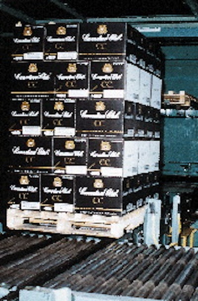 A pallet load of Canadian Club rides along a roller conveyor towards stretch wrapping. Palletization and stretch wrapping tasks